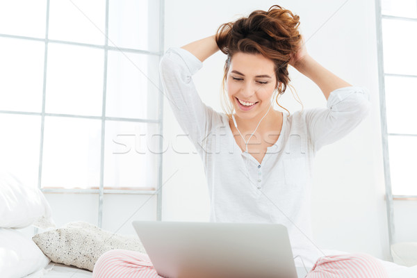 Foto stock: Mulher · usando · laptop · computador · cama · sorrindo · casa