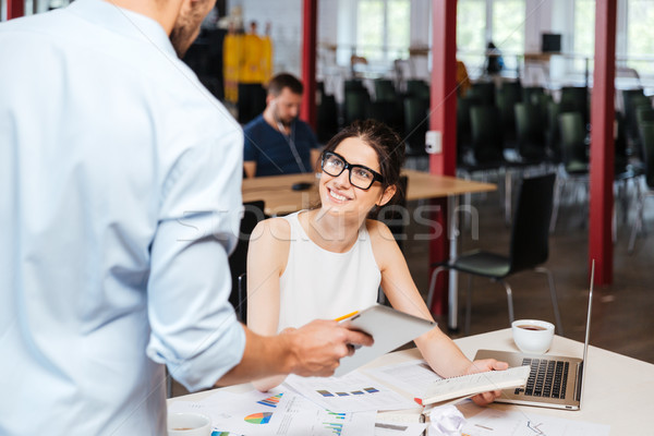 Cheerful business woman talking to collegue with tablet in office Stock photo © deandrobot