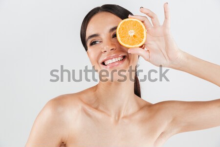 Stock photo: Portrait of a nude woman covering one eye with orange