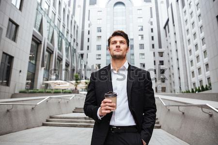 Cheerful young businessman reading newspaper and drinking coffee Stock photo © deandrobot