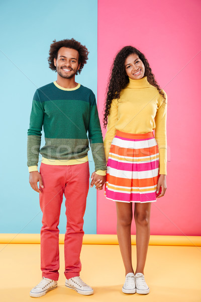 Happy african american young couple standing and holding hands Stock photo © deandrobot