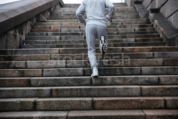 Blick zurück Mann läuft Treppe grau Sportbekleidung Stock foto © deandrobot