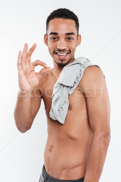 Cheerful african man make okay gesture. Stock photo © deandrobot