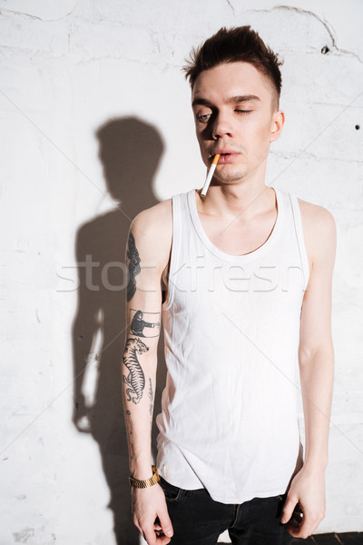 Serious man posing isolated over wall background. Stock photo © deandrobot