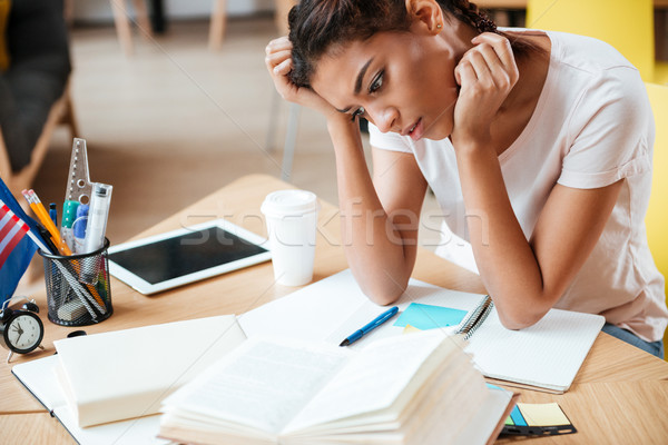 Thoughtful African woman in library Stock photo © deandrobot