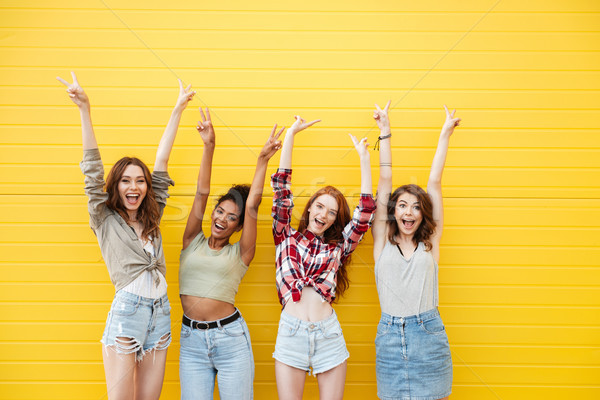 Foto stock: Sonriendo · mujeres · amigos · pie · amarillo · pared