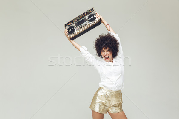 Emotional retro woman dressed in shirt holding boombox. Stock photo © deandrobot