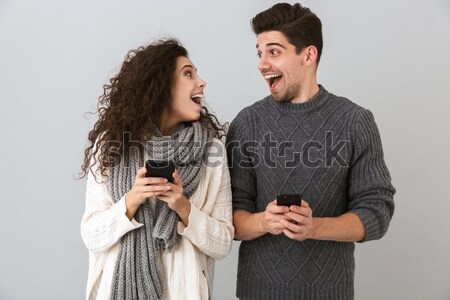 Charming young man showing biceps to his amazed girlfriend Stock photo © deandrobot