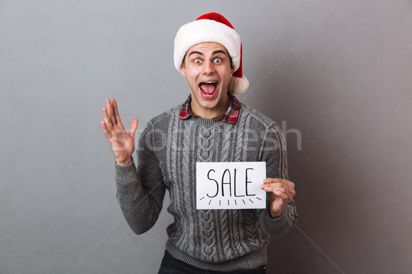 Surprised excited man wearing christmas santa hat Stock photo © deandrobot