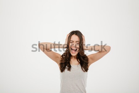 Image of Angry brunette woman screaming and covering her ears Stock photo © deandrobot