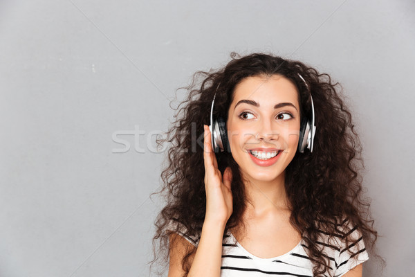 Great picture of curly caucasian woman in striped t-shirt in hea Stock photo © deandrobot