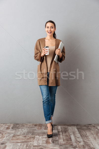Full length portrait of a satisfied young asian woman Stock photo © deandrobot