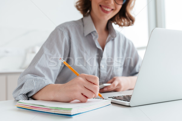 Cropped photo of young smiling woman in striped shirt taking not Stock photo © deandrobot