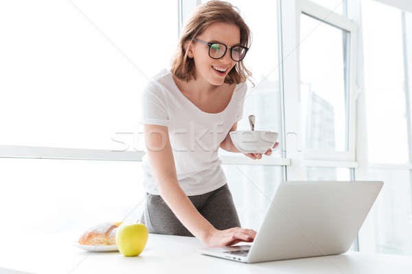 Mutlu genç şaşırtıcı kadın yazarak dizüstü bilgisayar Stok fotoğraf © deandrobot