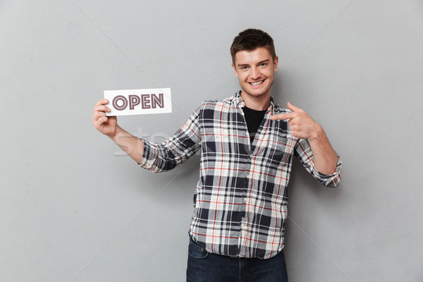 Portrait of an excited young man pointing finger Stock photo © deandrobot