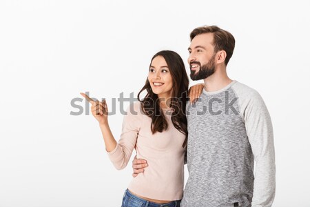 Cheerful young loving couple pointing. Stock photo © deandrobot