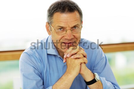 Senior man in glasses looking at camera Stock photo © deandrobot