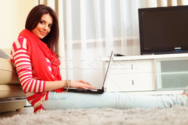 Portrait of a young woman at home sitting with laptop Stock photo © deandrobot