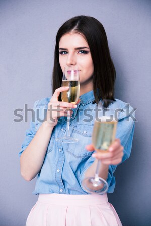 Woman holding glass of champagne and winking Stock photo © deandrobot