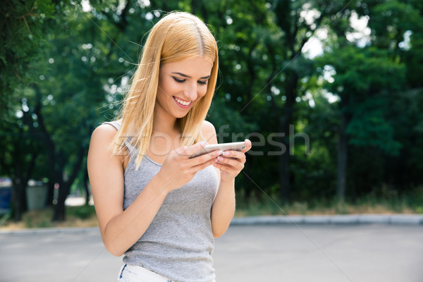 Gelukkig jong meisje smartphone buitenshuis meisje natuur Stockfoto © deandrobot
