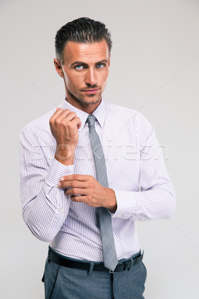 Businessman buttoning cuff sleeves Stock photo © deandrobot