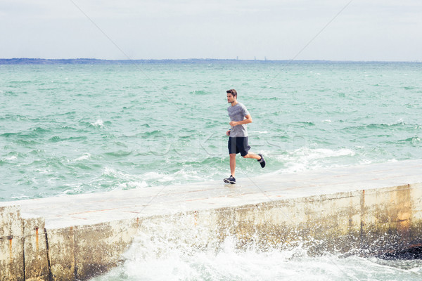 Portrait of a sports man running outdoors Stock photo © deandrobot