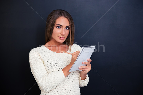 Beautiful woman making notes in notepad  Stock photo © deandrobot