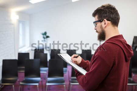 Business coach reading his speech in empty meeting room. Backside Stock photo © deandrobot