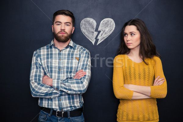 Couple after argument standing separately over blackboard background Stock photo © deandrobot