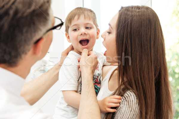 Dentist examining teeth of little boy at dental clinic Stock photo © deandrobot