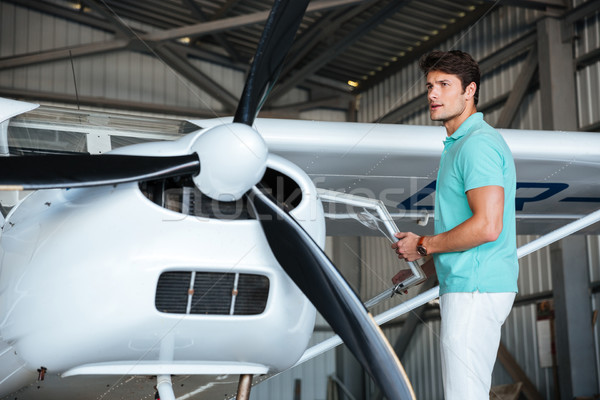 Man pilot standing near small private airplane Stock photo © deandrobot