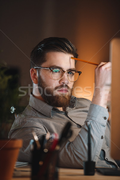 Attractive designer working at night and looking to computer Stock photo © deandrobot