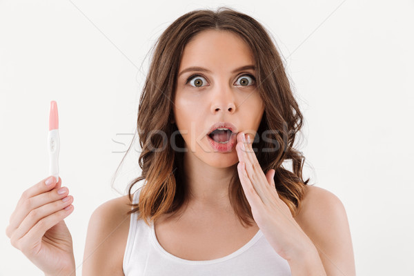 Megrémült barna hajú nő tart pozitív terhességi teszt Stock fotó © deandrobot