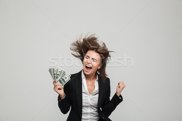 Portrait of a happy thrilled businesswoman in suit Stock photo © deandrobot
