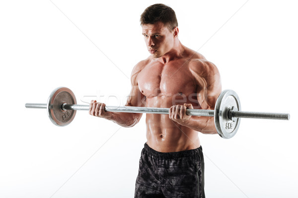 Young brutal muscular man exercising with barbell, looking aside Stock photo © deandrobot