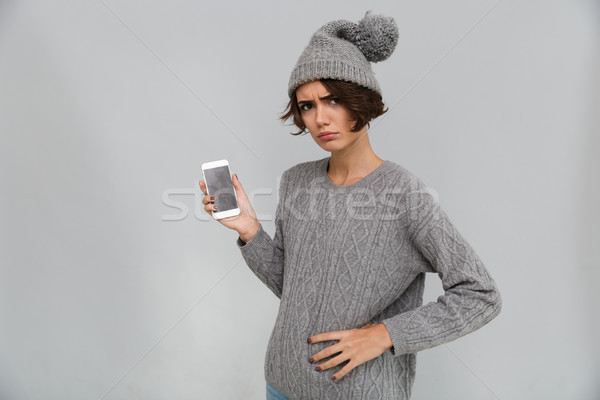Displeased sad young woman showing display of mobile phone. Stock photo © deandrobot