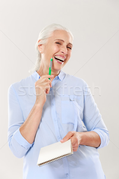 Happy woman with pen and notebook looking camera and smiling Stock photo © deandrobot