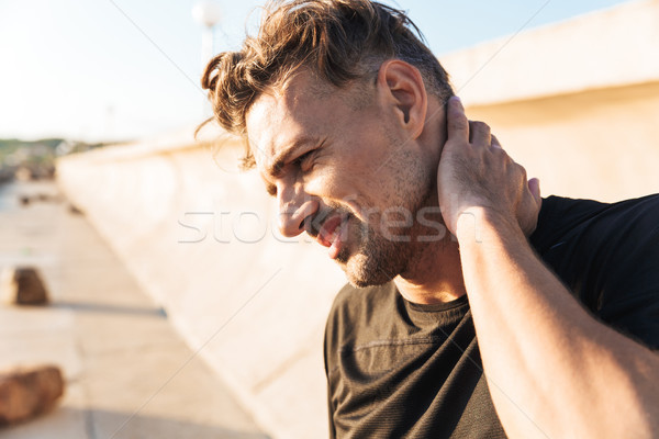 Portrait of an injured sportsman suffering from a neck pain Stock photo © deandrobot
