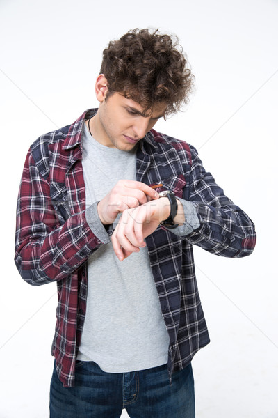 Casual man looking on the watch over gray background Stock photo © deandrobot