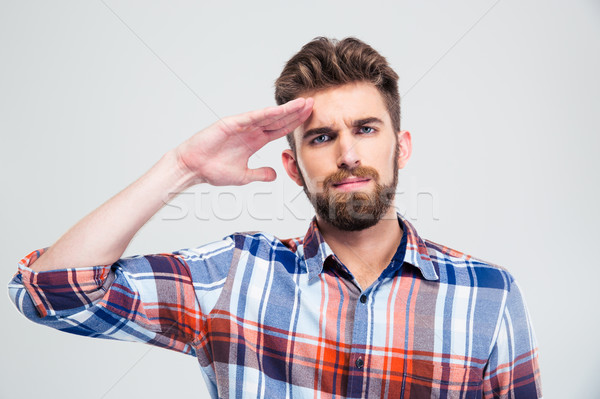 Portrait of a young man saluting Stock photo © deandrobot
