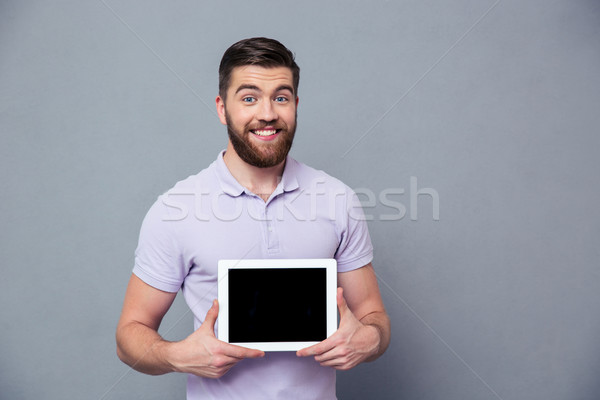 Smiling man showing blank tablet computer screen Stock photo © deandrobot
