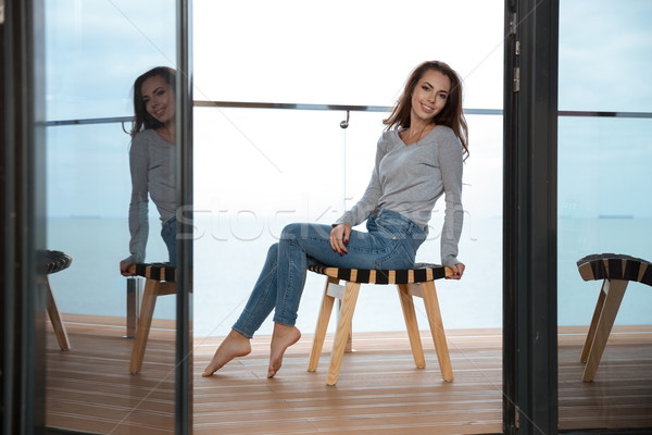 Beautiful girl sitting on chair and smiling Stock photo © deandrobot