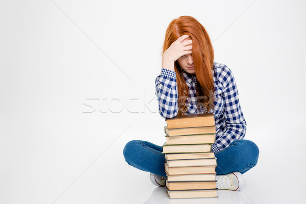 Sleepy lady leaning on stack of books and having headache  Stock photo © deandrobot