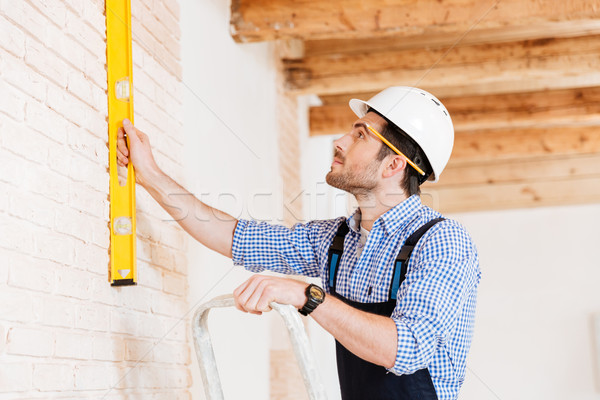 Close-up portrait of a builder using construction level Stock photo © deandrobot