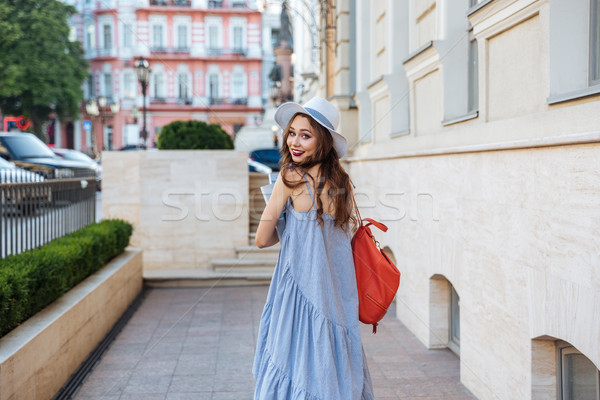Smiling woman with backpak and books walking on the street Stock photo © deandrobot