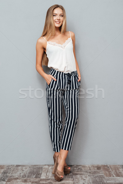 Full length portrait of a girl holding arms in pockets Stock photo © deandrobot