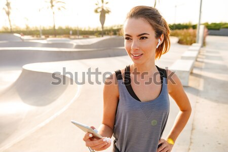 Handsome young mechanic in overall standing wirh smartphone near airplane Stock photo © deandrobot