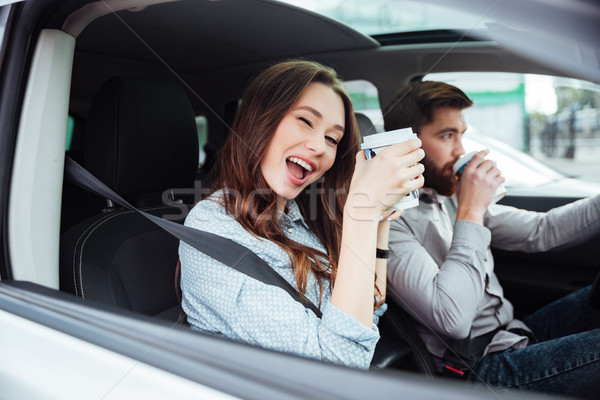 Happy couple in car with coffee Stock photo © deandrobot