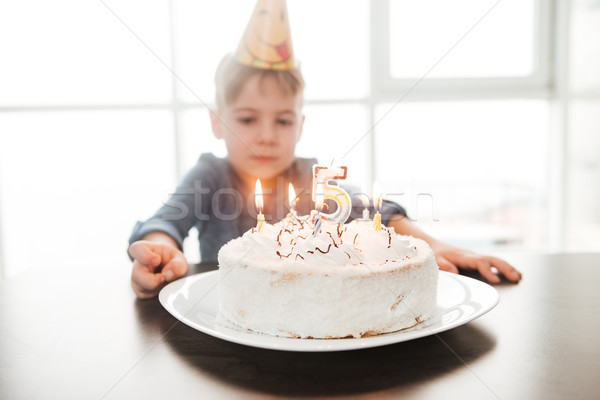 Birthday boy sitting in kitchen near cake Stock photo © deandrobot