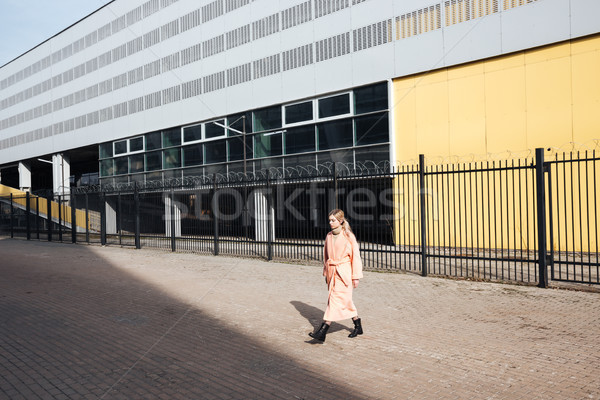 Serious young blonde lady walking outdoors. Looking aside. Stock photo © deandrobot